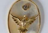 Pendente de ouro 18 k, feitio oval com madre pe... - Pendente de ouro 18 k, feitio oval com madre perola com pomba da Paz e um diamante de 5 cts.  (Por motivos de segurança a peça não se encontra n...