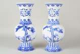 Par de vasos de porcelana oriental azul e branc... - Par de vasos de porcelana oriental azul e branca na forma de balaústres, decorados com elementos fitomórficos e ideogramas. Assinados na base.
