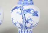 Par de vasos de porcelana oriental azul e branc... - Par de vasos de porcelana oriental azul e branca na forma de balaústres, decorados com elementos fitomórficos e ideogramas. Assinados na base.