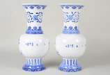 Par de vasos de porcelana oriental azul e branc... - Par de vasos de porcelana oriental azul e branca na forma de balaústres, decorados com elementos fitomórficos e ideogramas. Assinados na base.