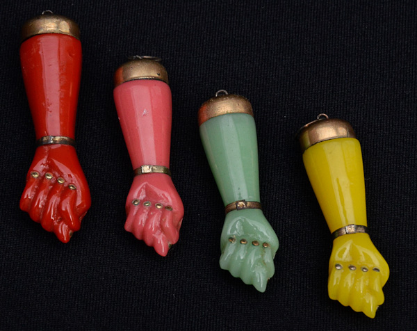Quatro pendentes na forma de figas (materiais diversos)