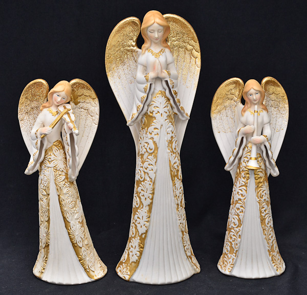 Tres estatuetas de porcelana branca e dourados repres.anjos, alt.21 a...