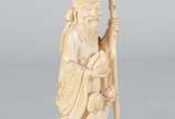 Escultura de marfim representando Shou Xing, o ... - Escultura de marfim representando Shou Xing, o deus da Longevidade, com figura de criança aos seus pés. Segura o pêssego e traz o cajado feito t...