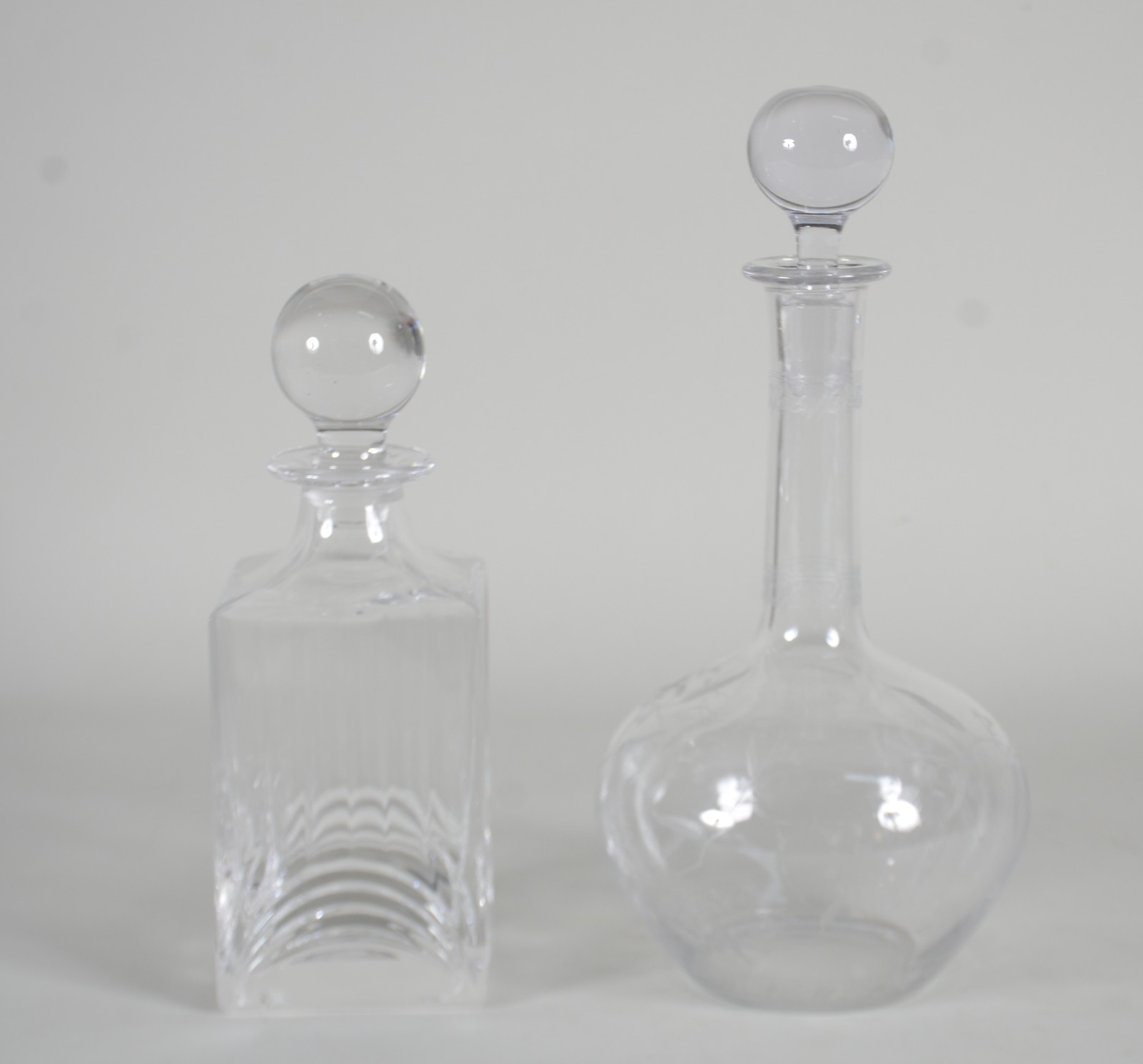 Duas garrafas de cristal, sendo uma quadrada lapidada em frisos e... - foto 1 de 9