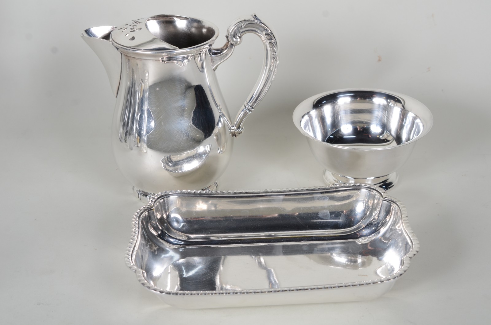 Três peças diversas de metal prateado, sendo: bowl; jarra para água e... - foto 1 de 11