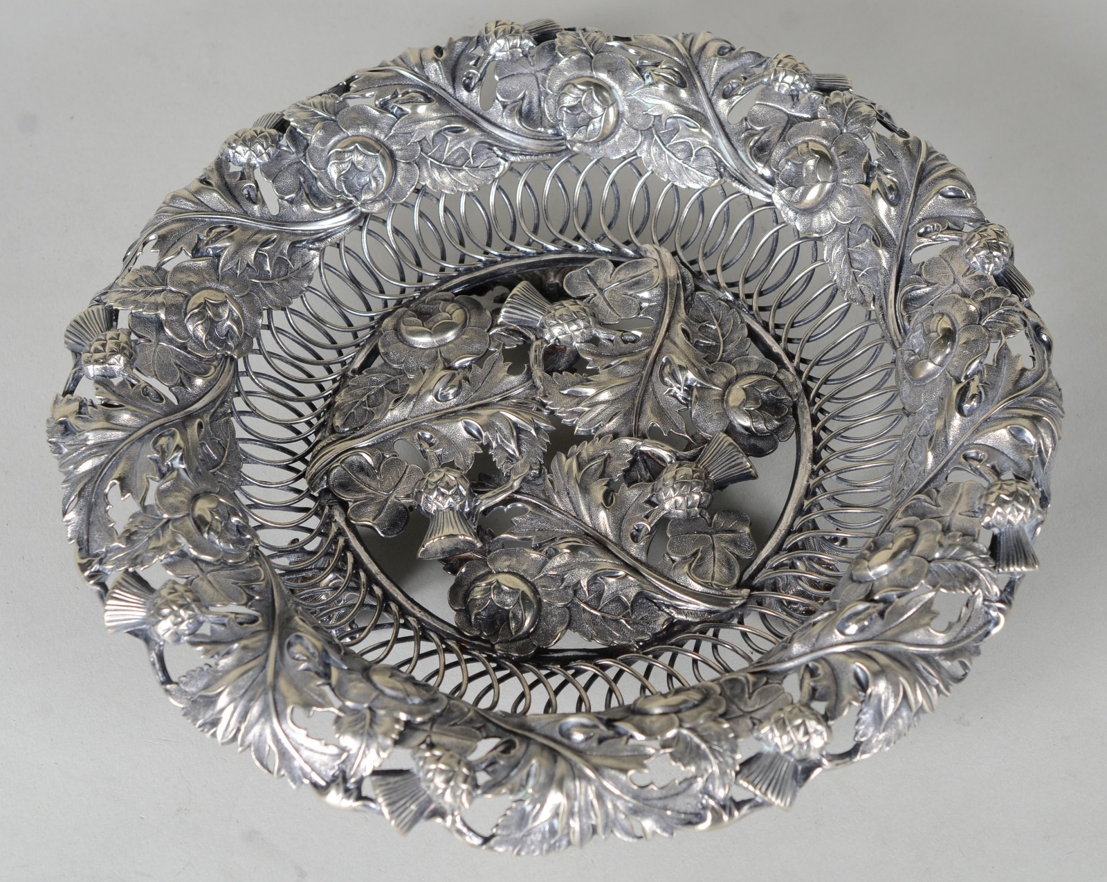 Cesta de metal prateado com flores e folhas em relevo, hastes vazadas. - foto 1 de 8