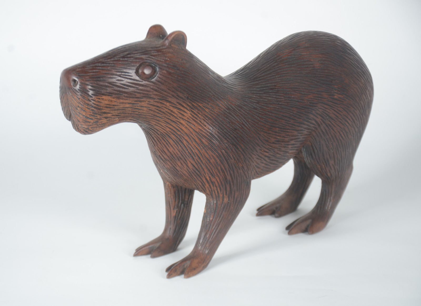 Escultura de madeira maciça representando capivara. - foto 1 de 6