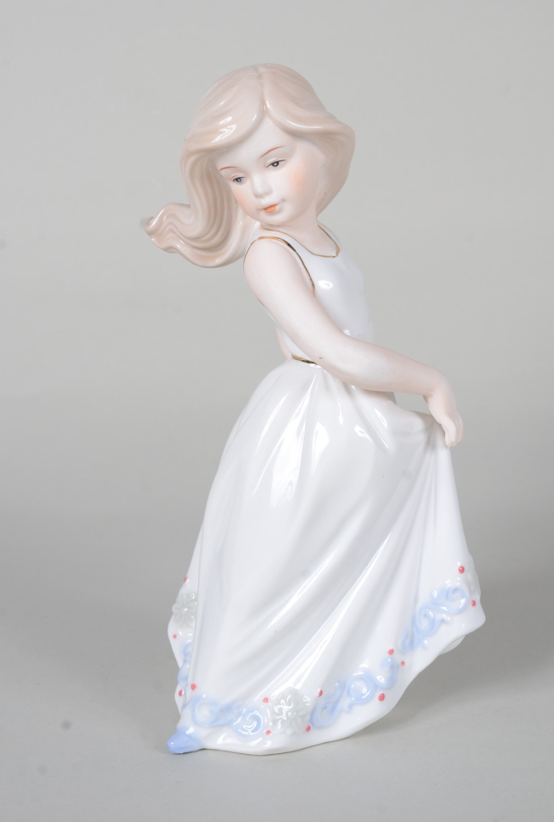 Escultura de porcelana policromada representando menina segurando... - foto 1 de 8