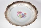 Centro de mesa de porcelana da Bavaria branca, ... - Centro de mesa de porcelana da Bavaria branca, borda com guirlandas douradas sobre friso fumé e centro com flores em policromia.