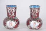 Par de pequenos vasos de metal esmaltado na cor... - Par de pequenos vasos de metal esmaltado na cor rubi, decorados com rostos femininos pintados sobre porcelana, guirlandas de prata. Pequenos ama...