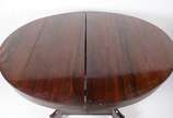 Mesa de jantar de madeira nobre, feitio oval (1... - Mesa de jantar de madeira nobre, feitio oval (1,26 x 1,10 m.) com 2 tabuas extensoras, medindo cada uma 39 cm x 110 cm., base em feitio quadrang...
