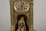 Elegante relógio de mesa de metal dourado, feit... - Elegante relógio de mesa de metal dourado, feitio neo gótico, decorado na base com figura feminina com cachorro, mostrador em algarismos romanos...