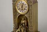 Elegante relógio de mesa de metal dourado, feit... - Elegante relógio de mesa de metal dourado, feitio neo gótico, decorado na base com figura feminina com cachorro, mostrador em algarismos romanos...
