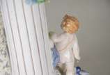 Fruteira de porcelana alemã policromada, base c... - Fruteira de porcelana alemã policromada, base com figura feminina recostada em coluna olhando para figura angelical com guirlandas florais, prat...
