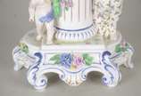 Fruteira de porcelana alemã policromada, base c... - Fruteira de porcelana alemã policromada, base com figura feminina recostada em coluna olhando para figura angelical com guirlandas florais, prat...