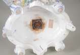 Fruteira de porcelana alemã policromada, base c... - Fruteira de porcelana alemã policromada, base com figura feminina recostada em coluna olhando para figura angelical com guirlandas florais, prat...