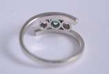 Anel de ouro branco com 2 brilhantes e uma esme... - Anel de ouro branco com 2 brilhantes e uma esmeralda central, aro 14. (Por motivos de segurança a peça não se encontra na loja)