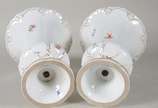 Meissen (1708),  - Par de vasos de porcelana alemã de Meissen, fundo branco decorado com flores policromadas e resquícios dourados, bordas recortadas. Um deles com "fio 
