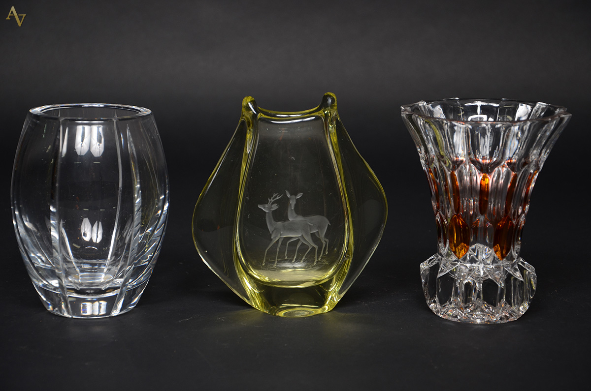 Três pequenos vasos de cristal, diversos. Alturas de 15 cm à 18 cm.
