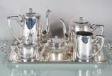 Wolff (1894),  - Baixela de chá e café de metal prateado com 6 peças, sendo 2 bules, leiteira, açucareiro, manteigueira e bandeja.