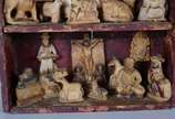 Antigo oratório em nicho de madeira com resquíc... - Antigo oratório em nicho de madeira com resquícios de policromia e figuras esculpidas em pedra sabão. Minas, século XIX.