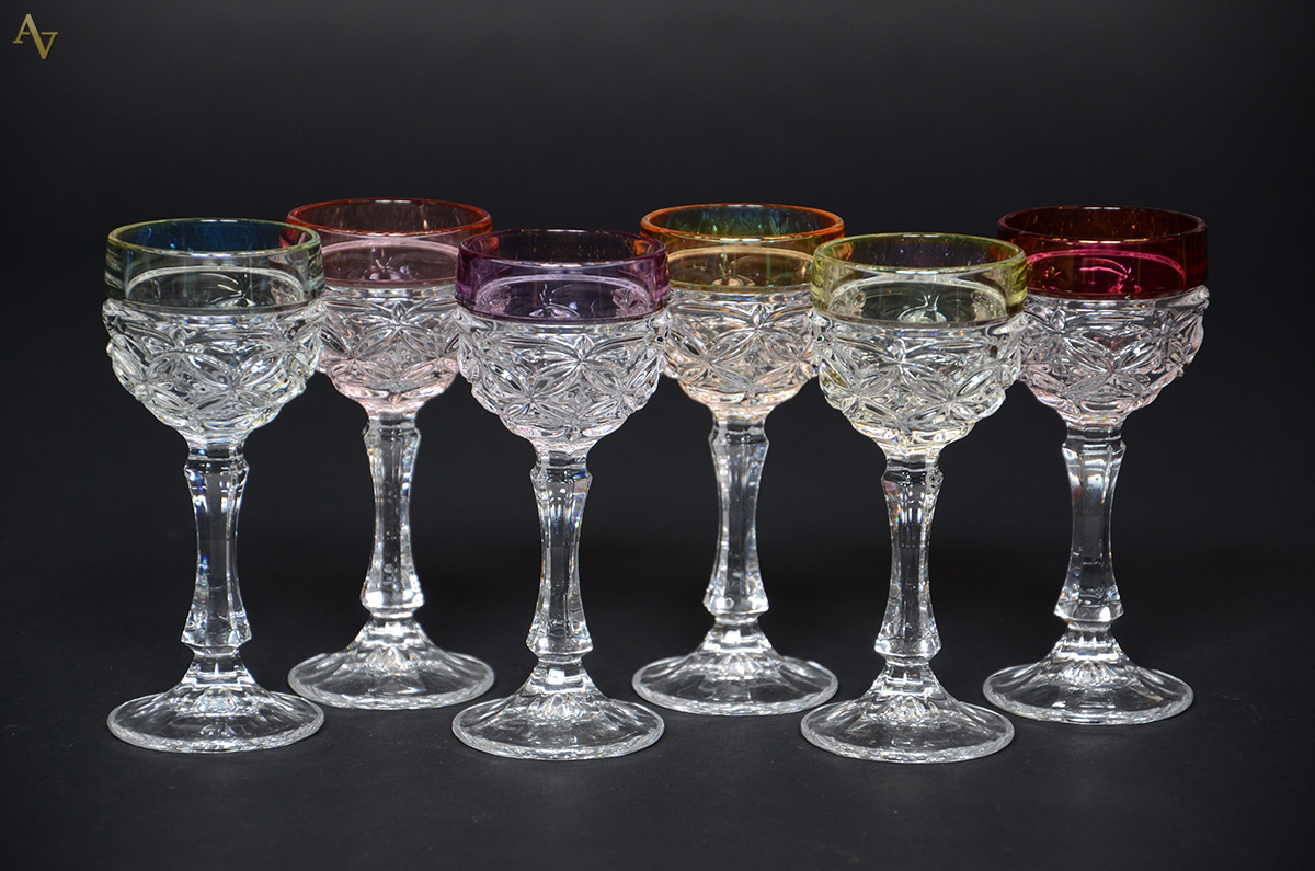 Seis cálices para licor de cristal com borda em diferentes cores.