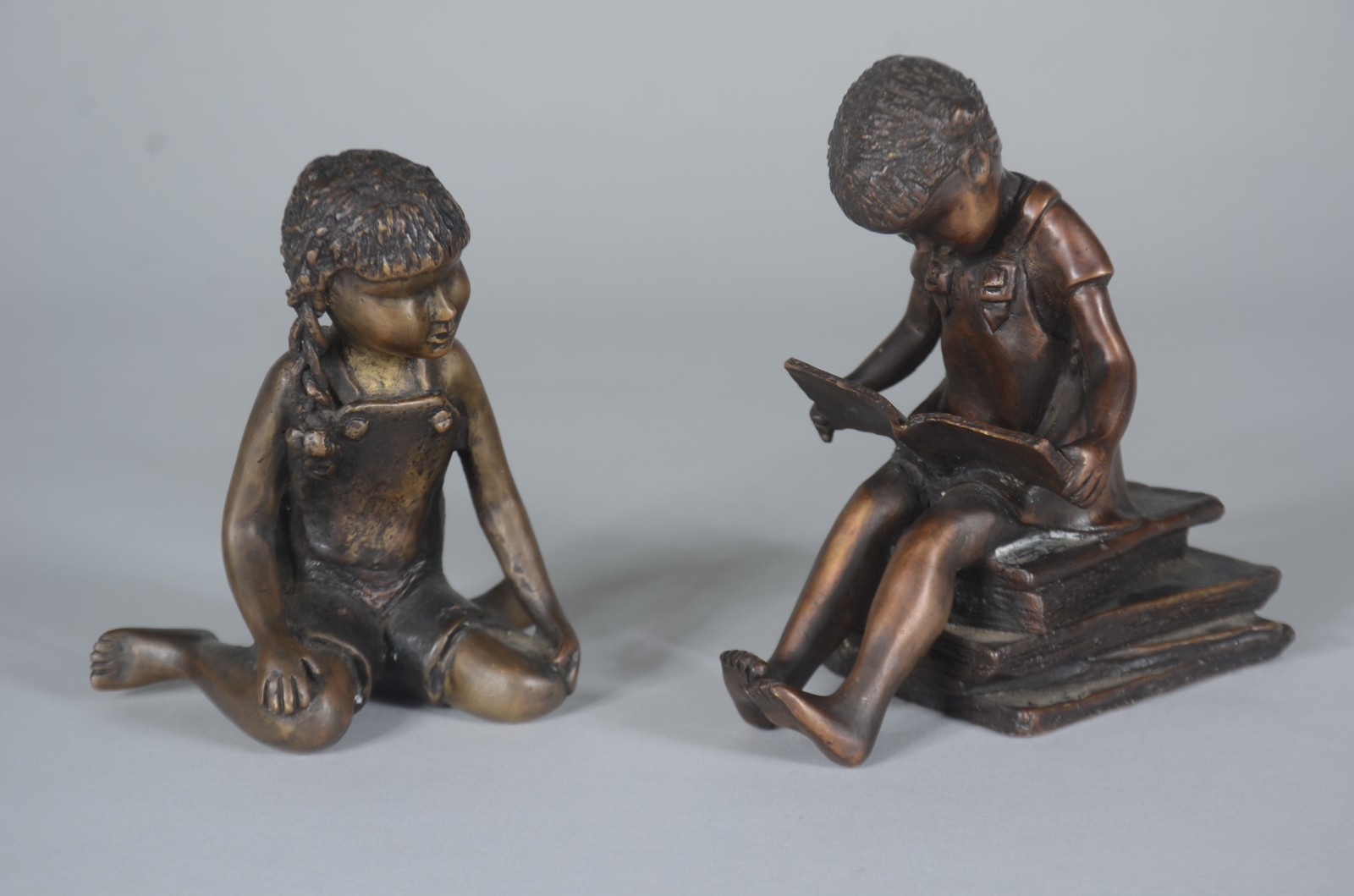 Duas esculturas de bronze representando meninas com livros, uma delas... - foto 1 de 6