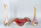 Três peças de vidro decorativo, sendo: par de v... - Três peças de vidro decorativo, sendo: par de vasos solifleurs com listras coloridas e centro de mesa vermelho com borda feitio babado.