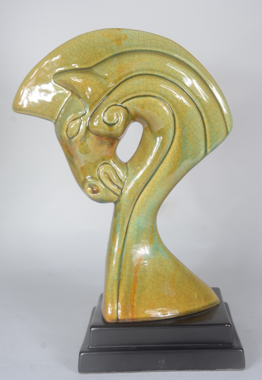 Escultura de cerâmica verde representando cabeça de cavalo estilizada. - foto 1 de 4