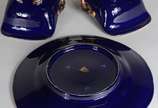 Três peças de porcelana azul cobalto com frisos... - Três peças de porcelana azul cobalto com frisos dourados, sendo: prato e par de cestas.