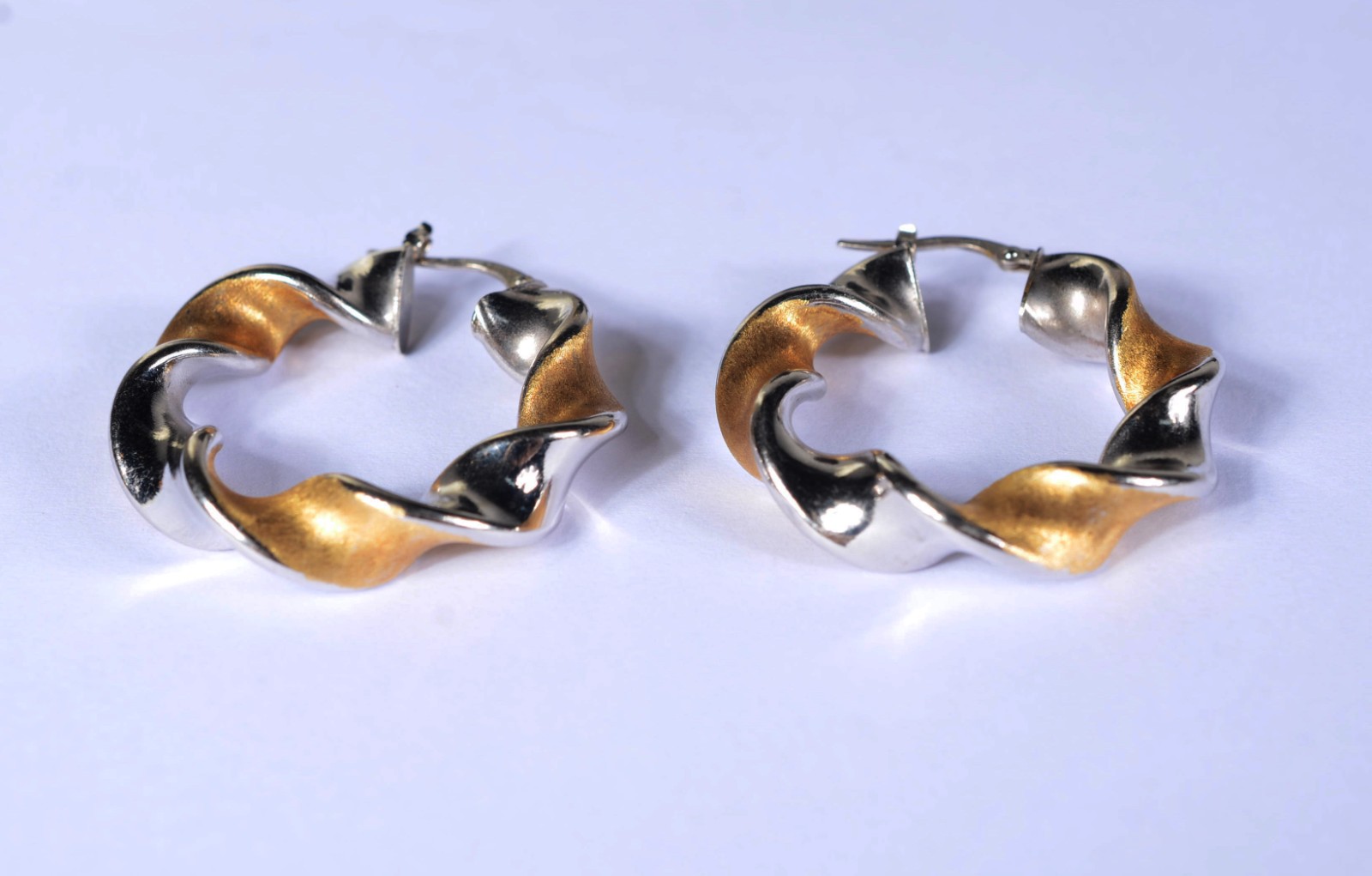 Par de argolas feitio "torcidas" de ouro 18 k., e ouro branco. (Por... - foto 1 de 4