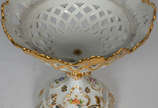 Elegante Fruteira de porcelana  francesa , bojo... - Elegante Fruteira de porcelana  francesa , bojo com vazados, borda recortada, flores em policromia e realces dourados.