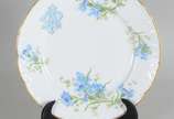 Limoges (1771),  - Prato de sobremesa de porcelana francesa Limoges, monogramado, decorado com flores em tons de azul e verde, borda recortada e realçada em dourado.