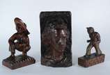 B.F. Heise,  - Três esculturas de madeira entalhada, sendo: Placa com rosto de jovem, assinada B.F.Heise, 1945; Figura de homem agachado com chapéu; e, figura mascul
