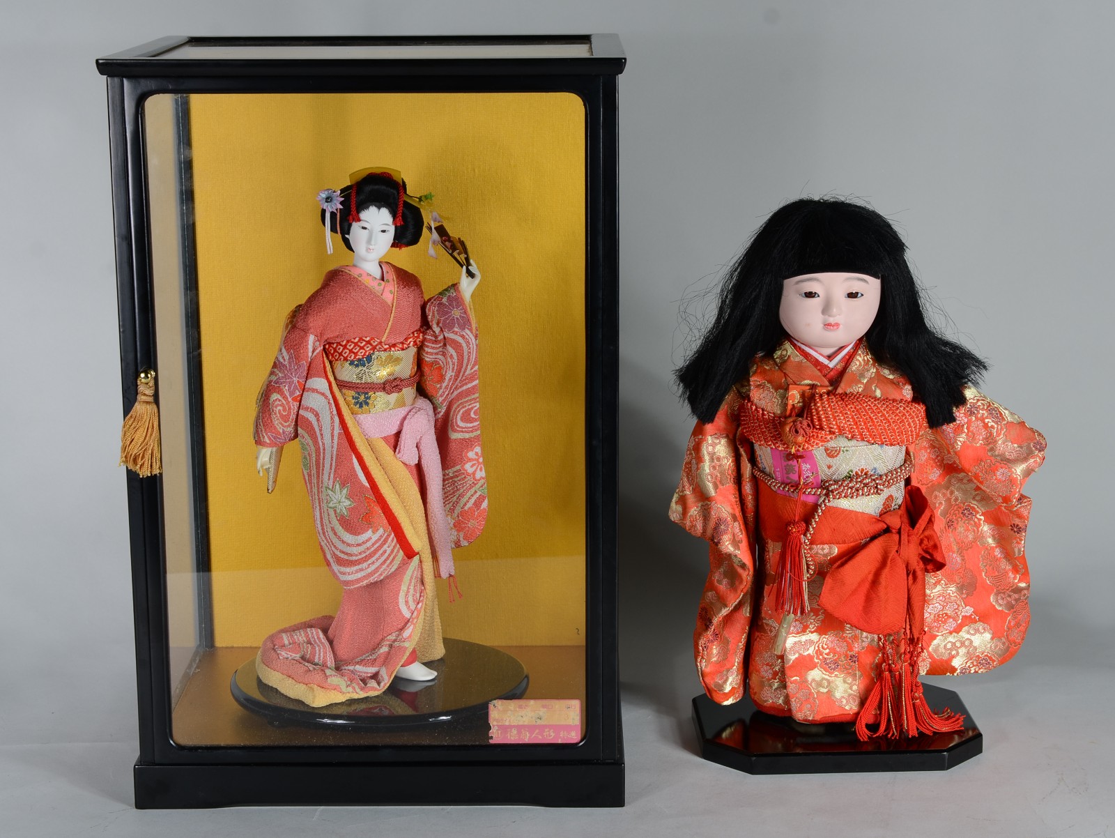 Duas peças, sendo: boneca japonesa com redoma e boneca com rosto de... - foto 1 de 10