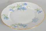 Limoges (1771),  - Prato de sobremesa de porcelana francesa Limoges, monogramado, decorado com flores em tons de azul e verde, borda recortada e realçada em dourado.