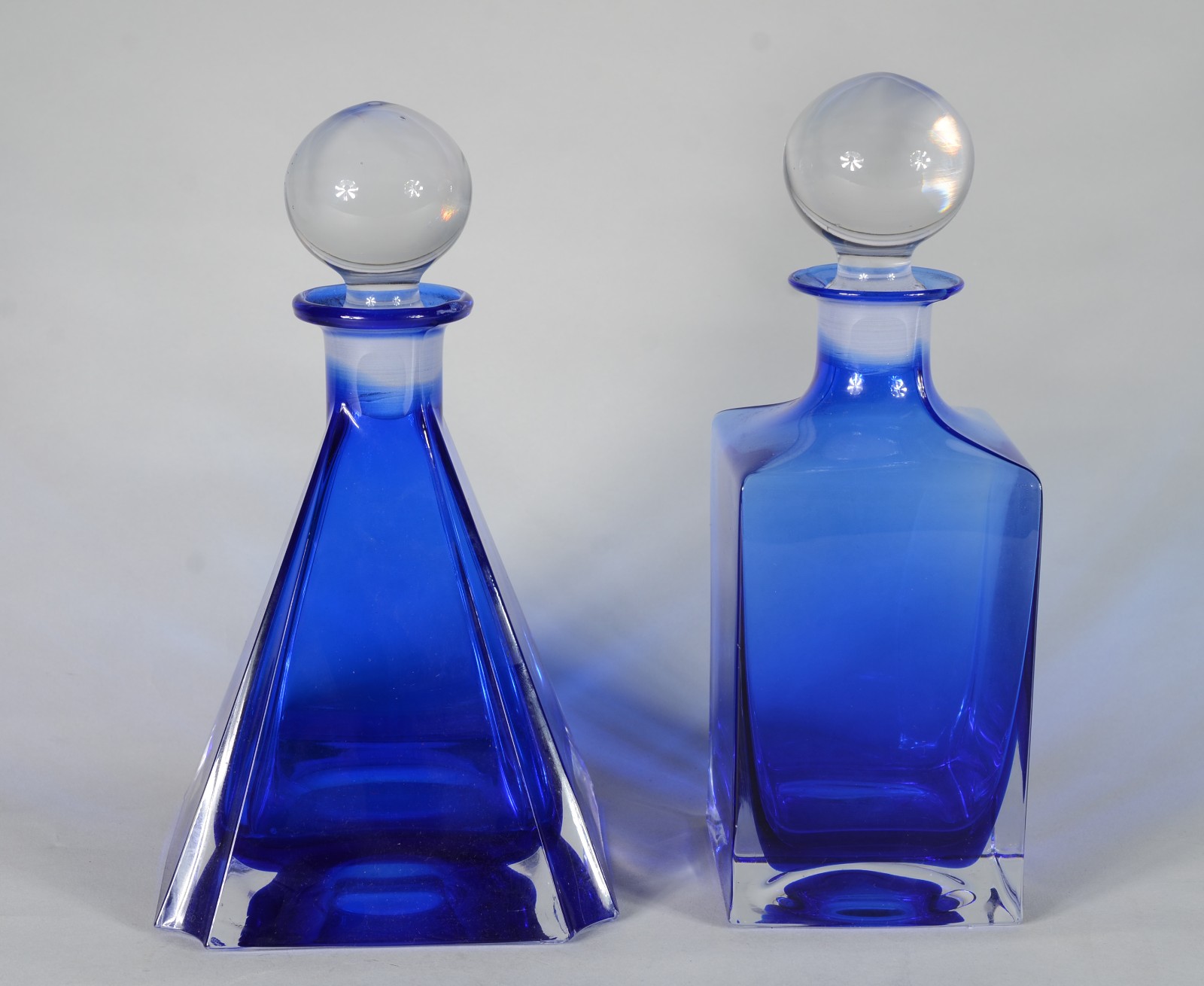 Duas garrafas de cristal na cor azul, sendo uma na forma de pirâmide... - foto 1 de 7