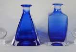 Duas garrafas de cristal na cor azul, sendo uma... - Duas garrafas de cristal na cor azul, sendo uma na forma de pirâmide e outra quadrangular, tampas em "bola".