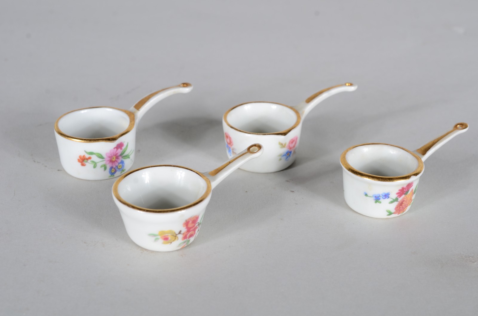 Quatro miniaturas de panelas de porcelana francesa, fundo branco e... - foto 1 de 5