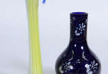 Dois vasos de vidro, sendo um na forma de "Copo... - Dois vasos de vidro, sendo um na forma de "Copo de leite" amarelo e outro na cor azul com flores brancas , altura da peça maior .