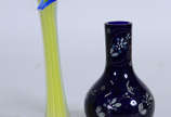 Dois vasos de vidro, sendo um na forma de "Copo... - Dois vasos de vidro, sendo um na forma de "Copo de leite" amarelo e outro na cor azul com flores brancas , altura da peça maior .