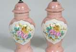 Par de pequenas ânforas de porcelana, fundo ros... - Par de pequenas ânforas de porcelana, fundo rosa com flores pintadas á mão em policromia e realces dourados. Uma delas com rachadura.