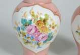 Par de pequenas ânforas de porcelana, fundo ros... - Par de pequenas ânforas de porcelana, fundo rosa com flores pintadas á mão em policromia e realces dourados. Uma delas com rachadura.