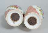 Par de pequenas ânforas de porcelana, fundo ros... - Par de pequenas ânforas de porcelana, fundo rosa com flores pintadas á mão em policromia e realces dourados. Uma delas com rachadura.