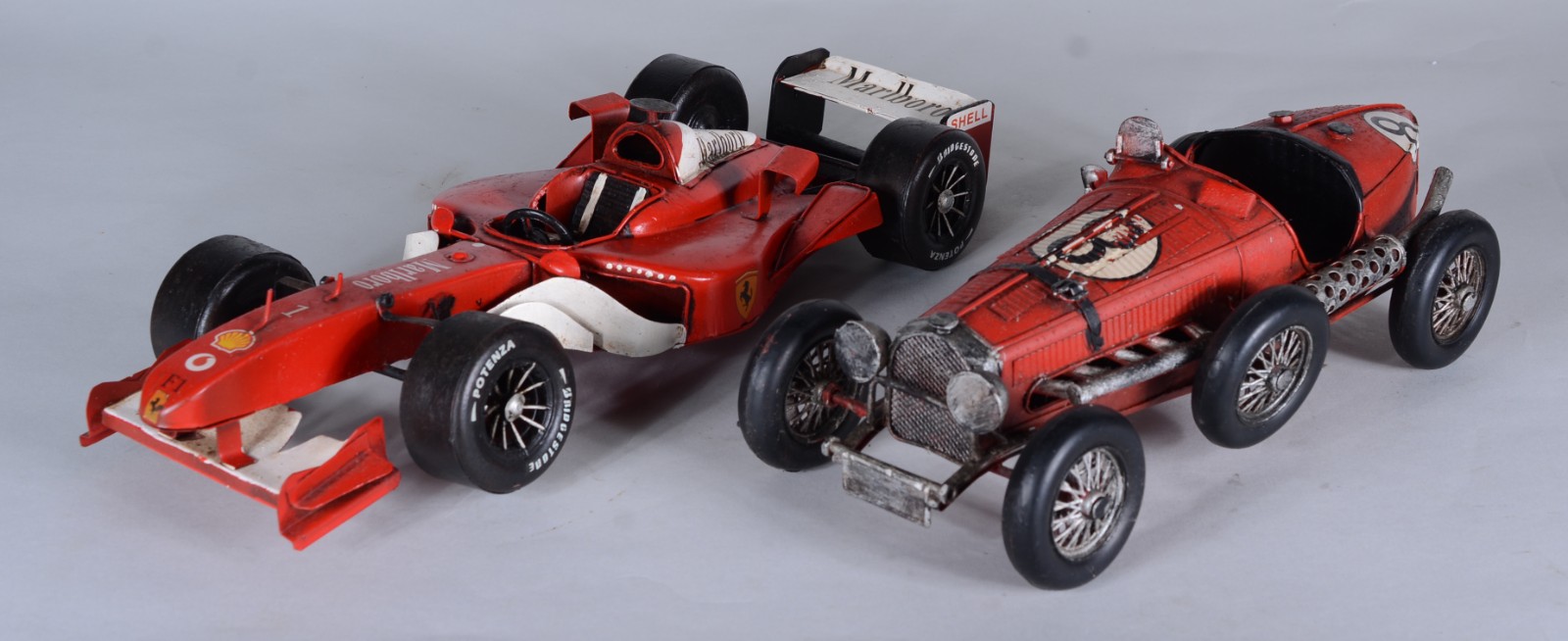 Dois brinquedos representando antigos carros de corrida em miniaturas. - foto 1 de 10