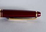 Montblanc (1906),  - Caneta "Meisterstuck" na cor vinho com dourado, no estojo.