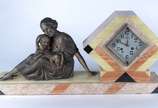 Relógio de mesa Art deco de mármore e ônix deco... - Relógio de mesa Art deco de mármore e ônix decorado com grupo escultórico de metal representando "Figura feminina com criança". Pequeno trincado...