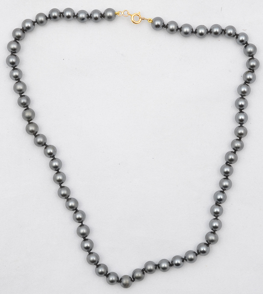 Colar de um fio, com 56 pérolas negras de 75 mm cada, fecho em ouro...