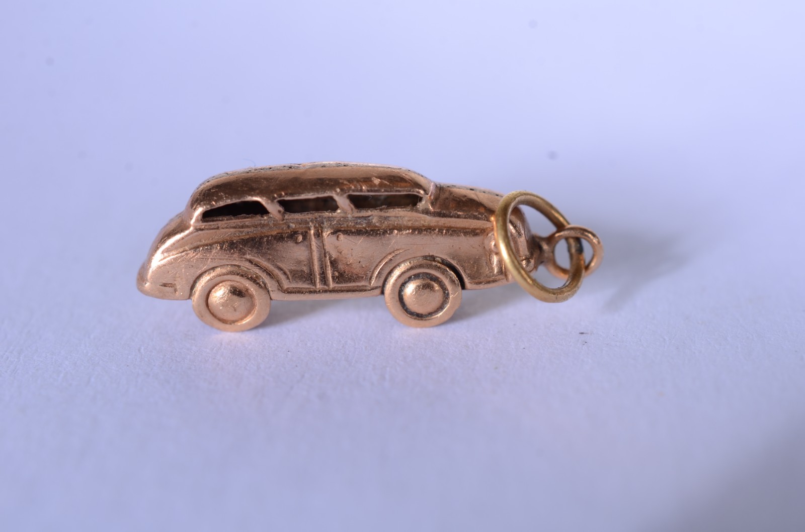 Três pendentes de ouro baixo, sendo: cruz; pomba e carro. (Por... - foto 3 de 5