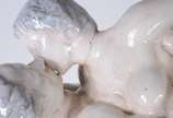 Relógio de mesa encimado por grupo escultórico ... - Relógio de mesa encimado por grupo escultórico de porcelana representando casal se beijando. Com pequenos desgastes e pequenos quebrados, pescoç...